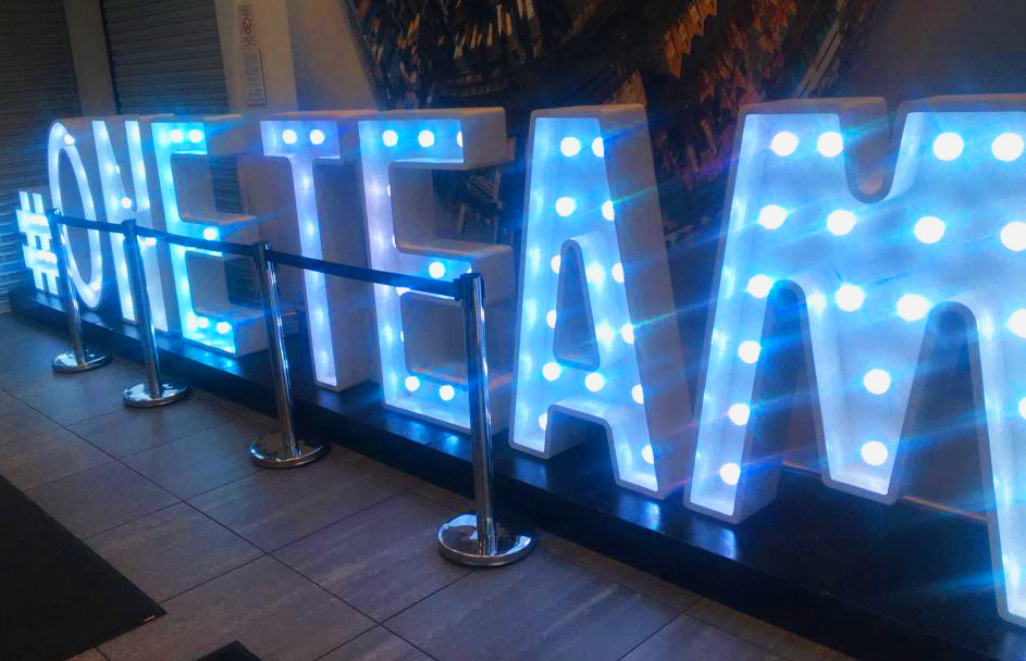 A sign made out of lights that says #OneTeam