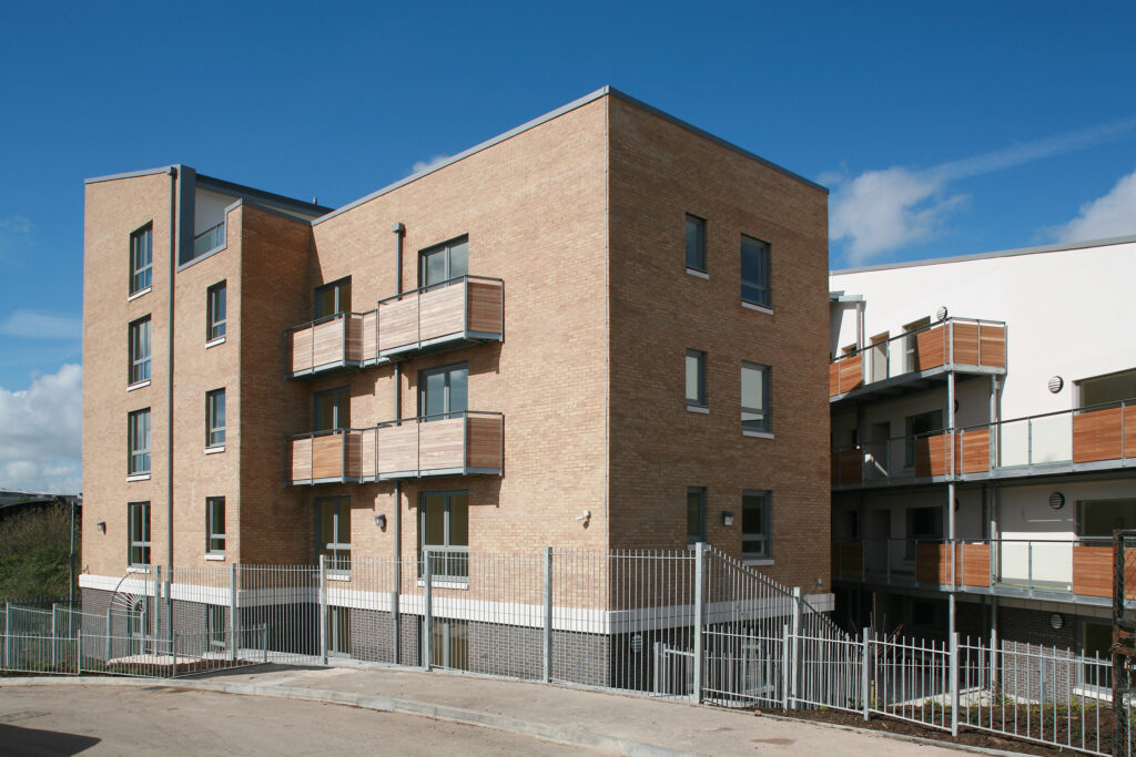 A block of newly built flats against a bright blue sky