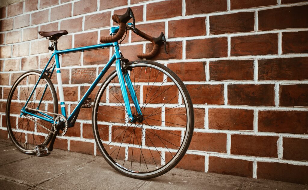 Blue bike against a red brick wall