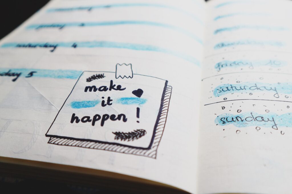 An open notebook with the words 'Make it Happen!' illustrated